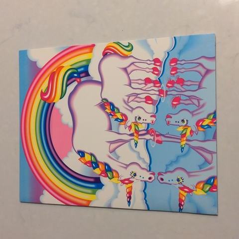 Lisa Frank three-ring folder showing a white unicorn with a rainbow mane beside a rainbow arc and smaller winged unicorns in a blue sky