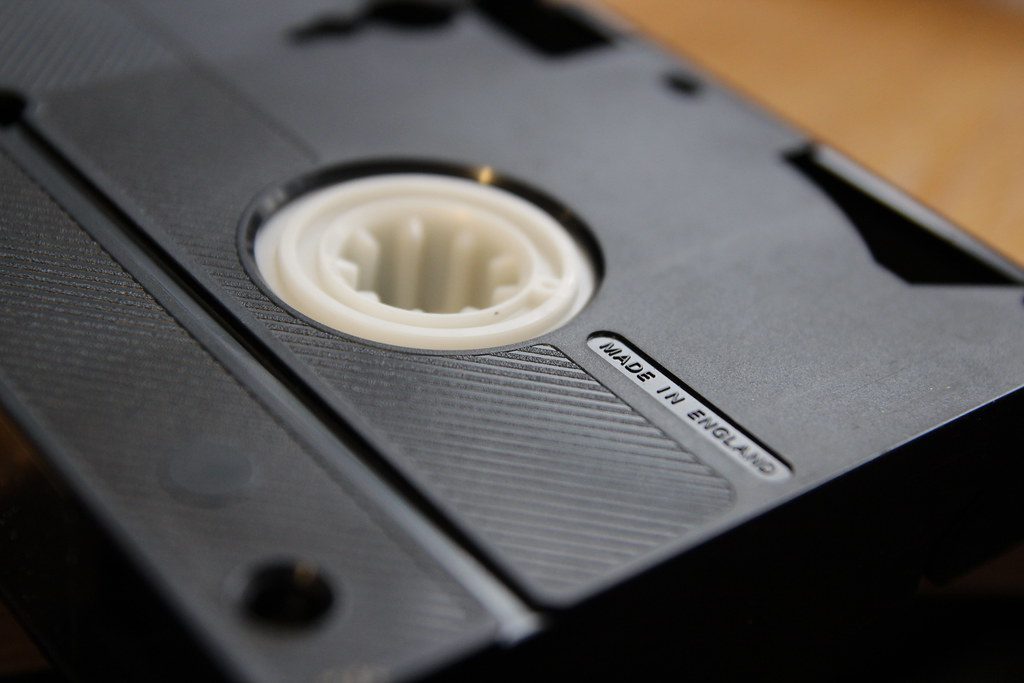 Close-up of the underside of a black VHS video cassette showing its white tape spool.